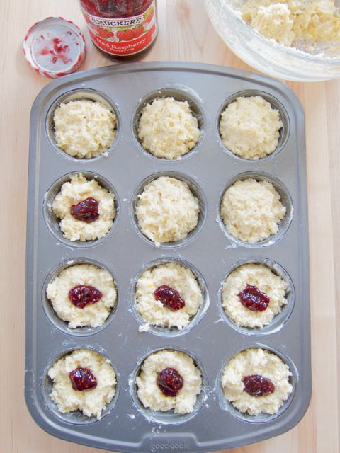 putting jam in muffins