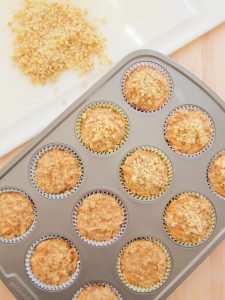 putting chopped nuts on Gluten-Free Apple and Carrot Muffins With Nuts and Oats