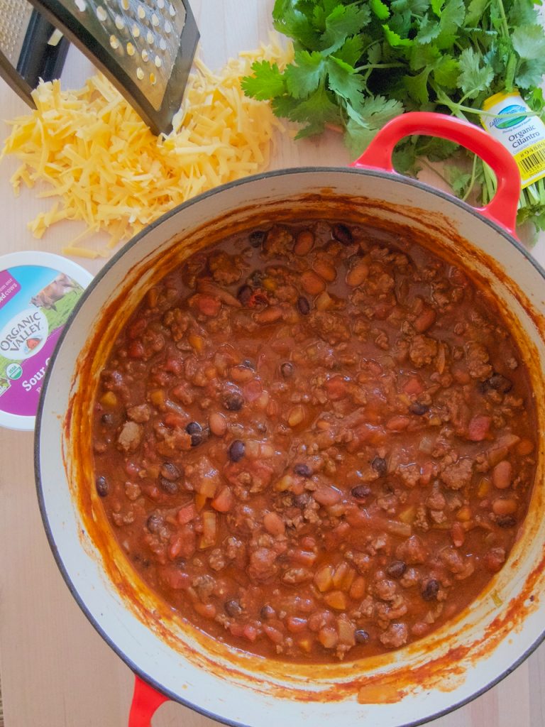 pot of chili with cheese and cilantro