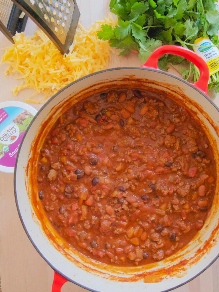 pot of chili with cheese and cilantro